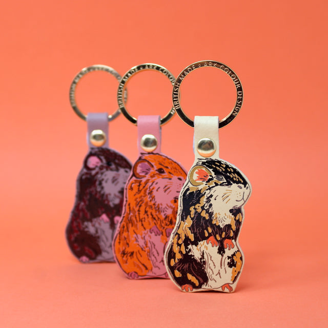 Three guinea pig leather keyings with a gold plated ring. Handmade in Cambridge using hot foil.