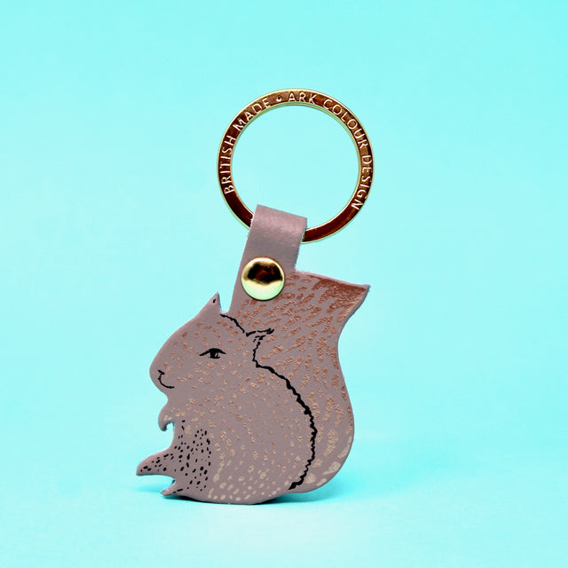 A nude coloured squirrel key ring design on a gold plated ring with 'nuts' on the reverse.