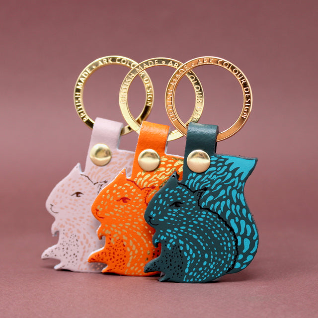 Three squirrel keychains with a gold plated ring.