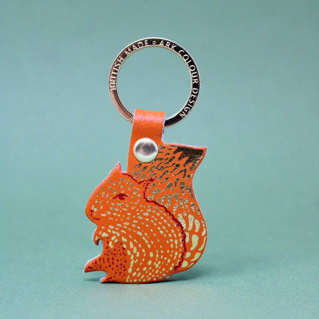 An orange squirrel key ring design on a gold plated ring with 'nuts' on the reverse.